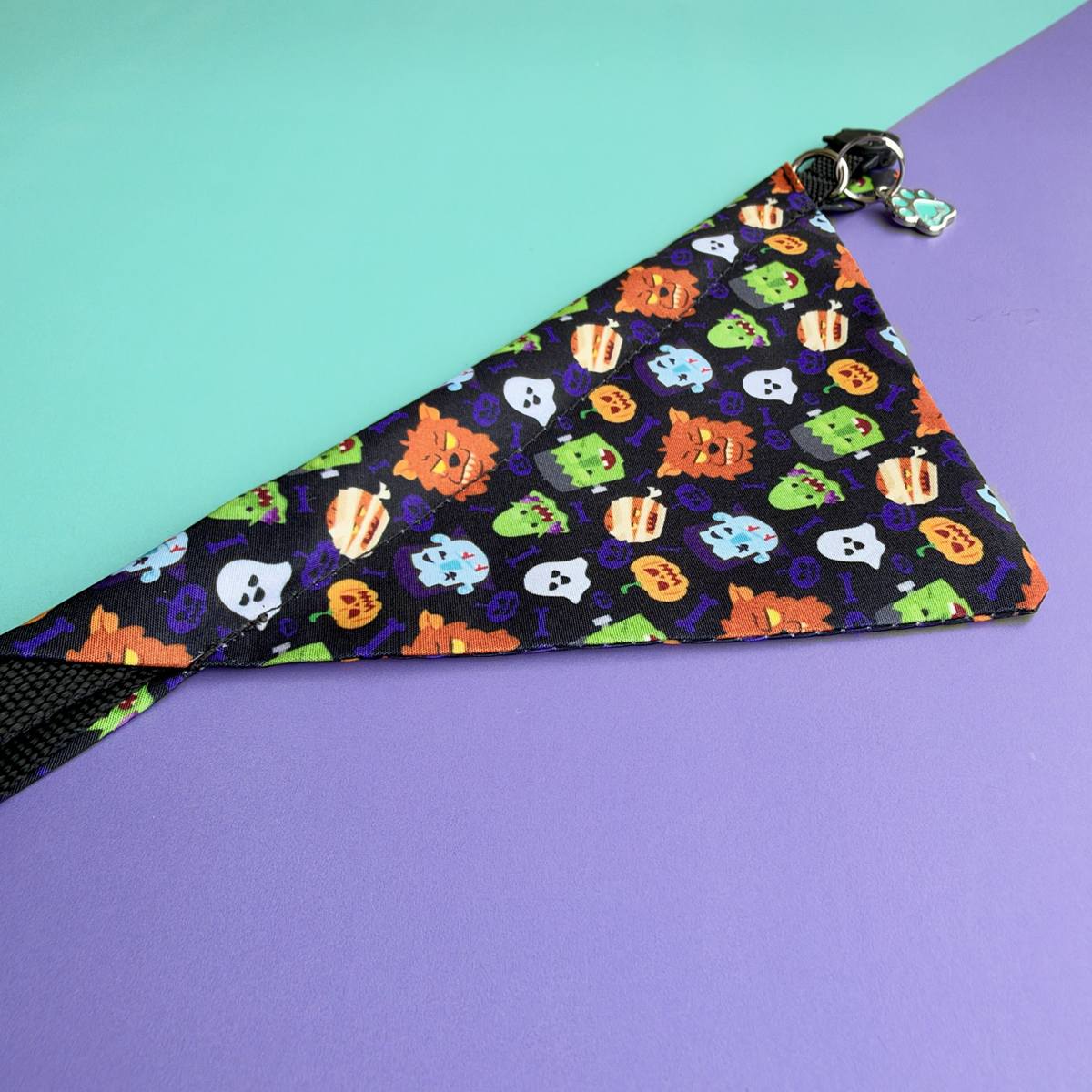 Detalle del estampado de monstruos, fantasmas y calabazas de la pañoleta para gatos