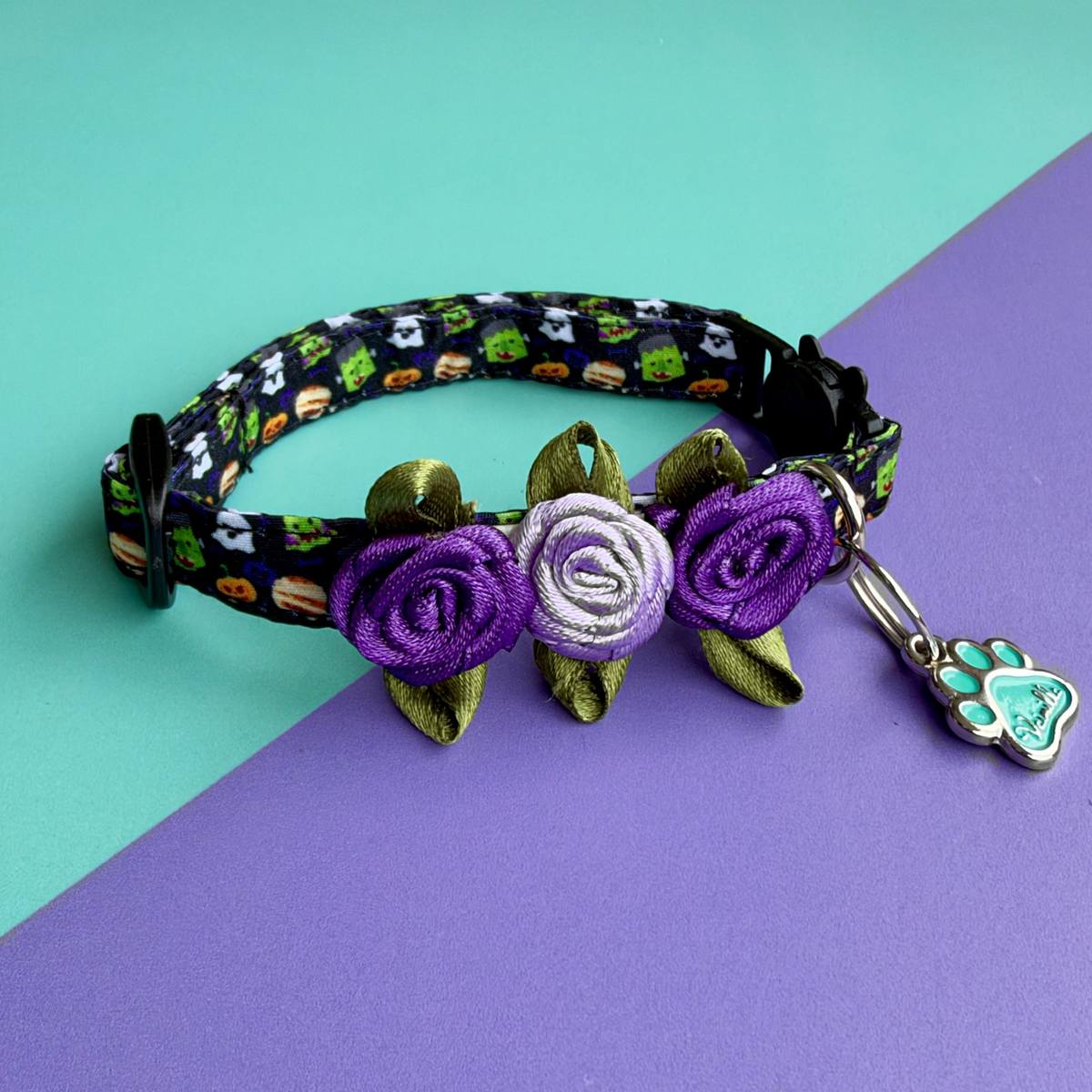 Collar para gatos Halloween Monstruos con tres rosas moradas y lila, sobre fondo aguamarina y lila